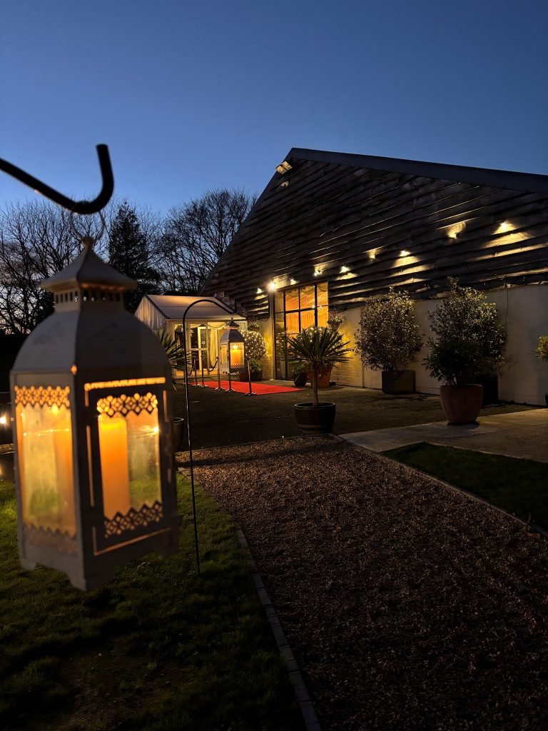 Selden Barns lit up at dusk with lanterns along the path