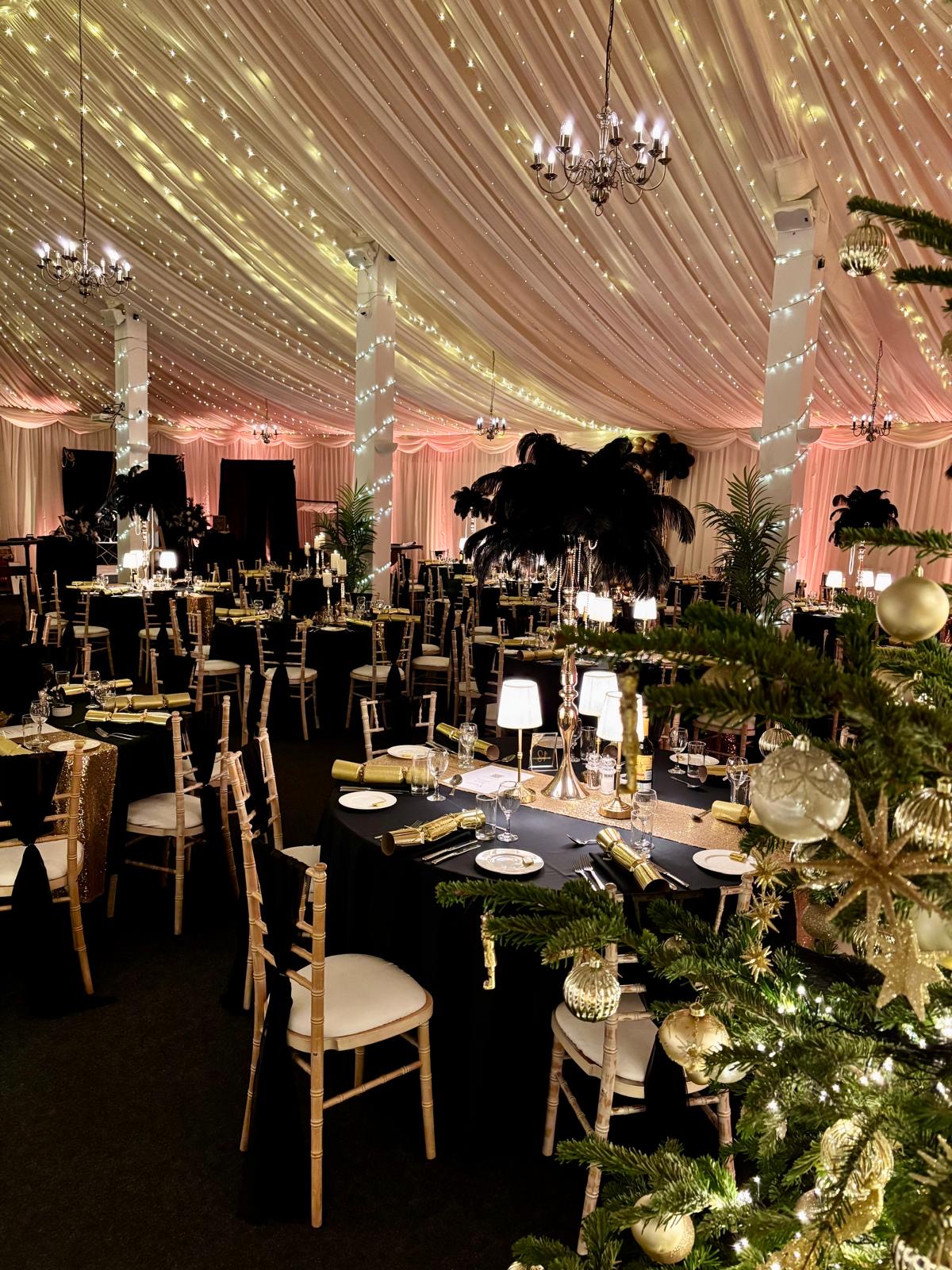 Festive dining tables with Christmas tree and chandeliers in the main barn